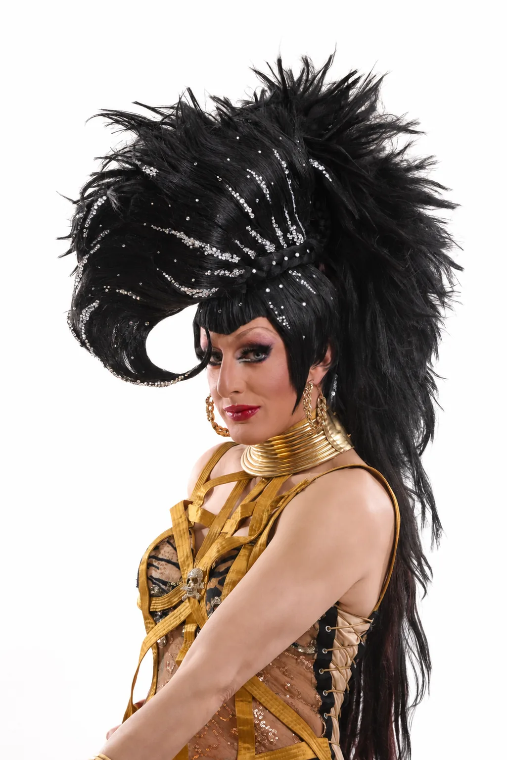 Lady Maxx, coiffe de plumes noires et bustier doré