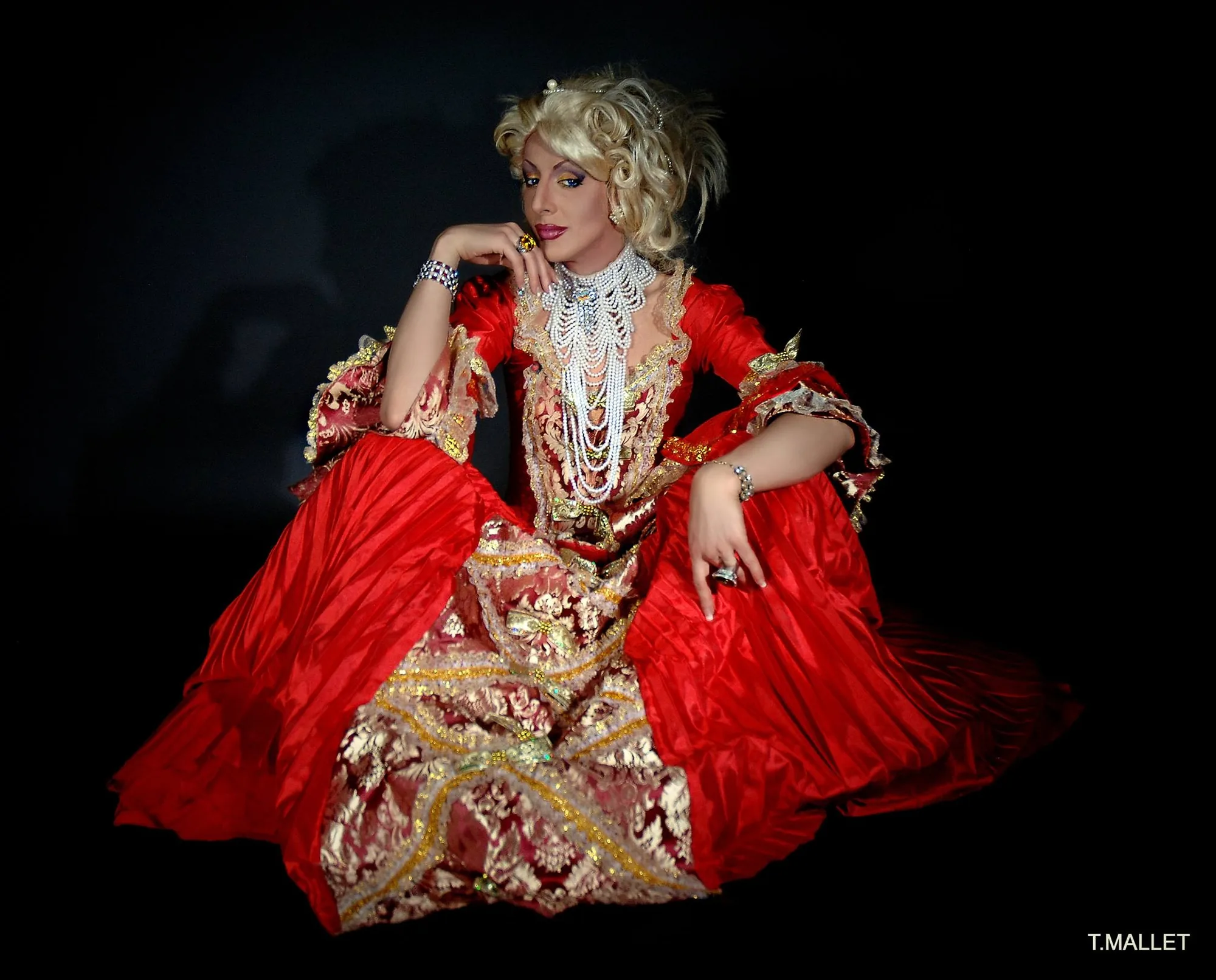 Lady Maxx en robe rouge et or, pose sur scène