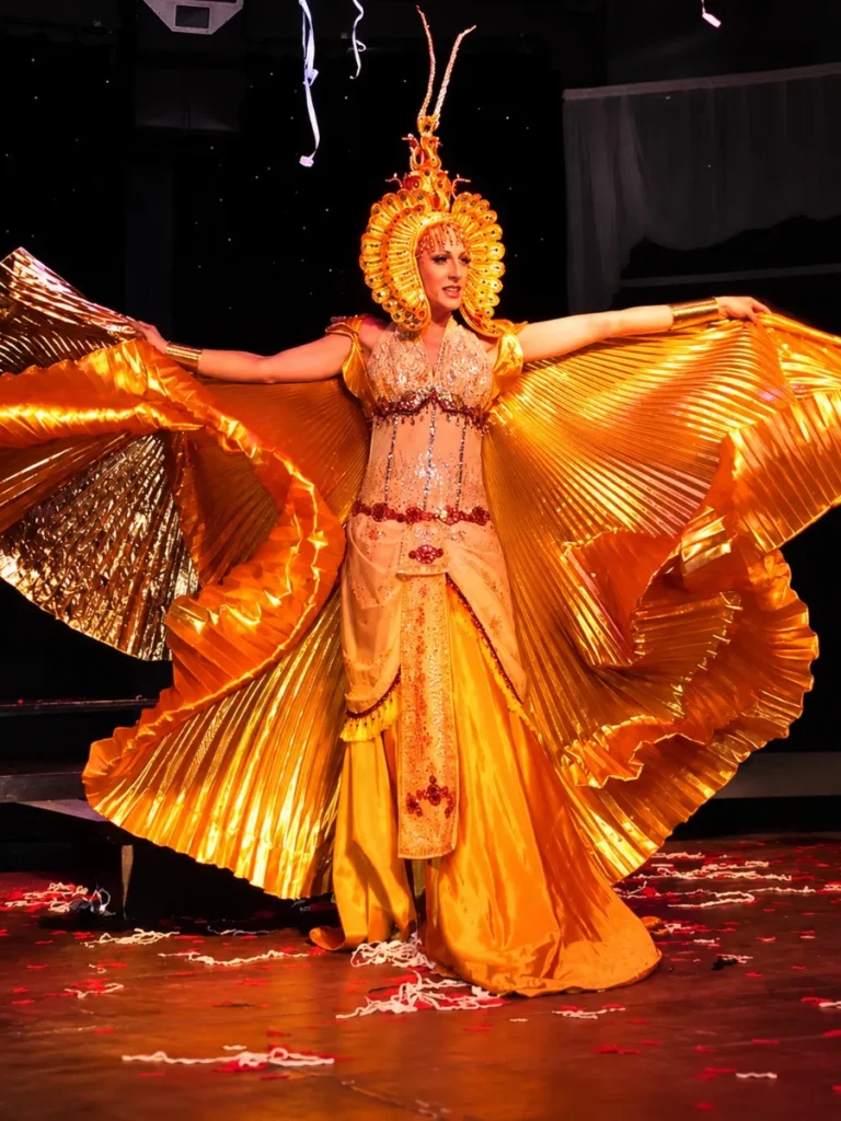 Lady Maxx en ailes dorées et coiffe soleil, final du spectacle cabaret transformiste