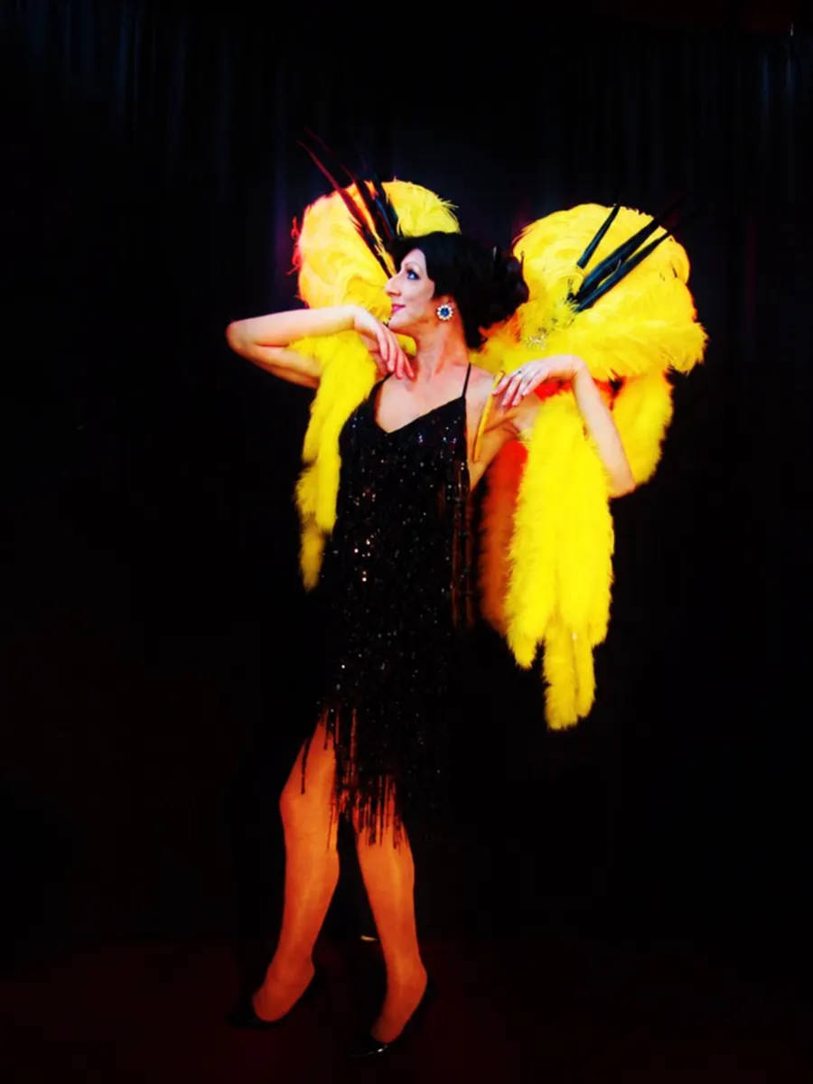 Lady Maxx en robe charleston et éventails de plumes jaunes, numéro années folles
