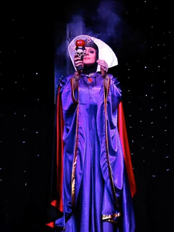 Lady Maxx en reine de Blanche-Neige tenant la pomme empoisonnée, spectacle cabaret