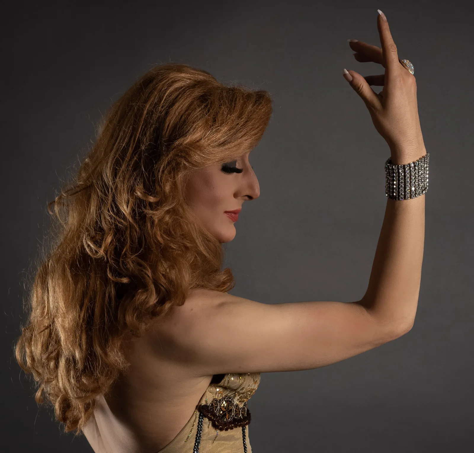 Lady Maxx, artiste transformiste, en Dalida : portrait studio de profil, chevelure rousse et bracelet strass
